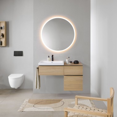 Bathroom with grey walls, bathroom furniture in wood and a round illuminated mirror