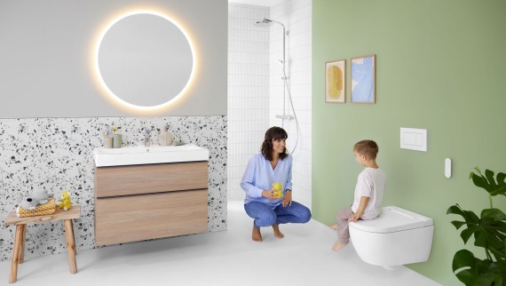 Woman and child in a colorful bathroom with lighted mirror wall-hung toilet