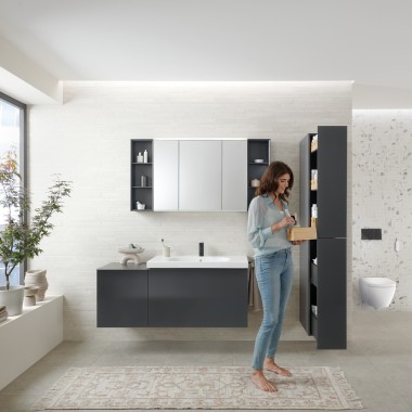 Woman opens tall cabinet with lots of storage space in bathroom