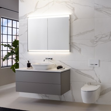 Wall with marble tiles, washbasin, and mirror cabinet with light